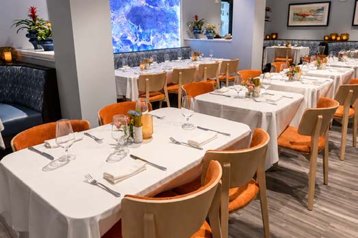 Main Dining Room and Bar set with white tablecloths and coastal-inspired interiors