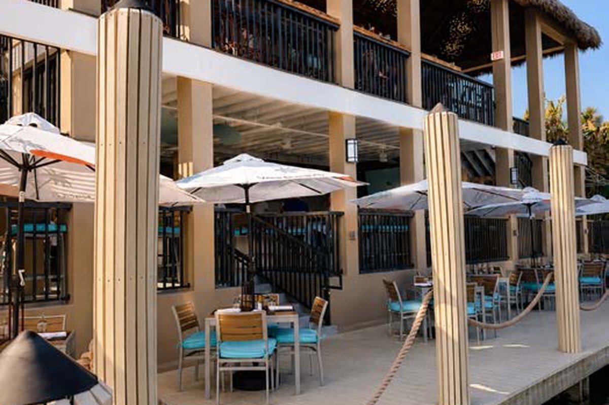 The Dock waterfront dining tables with umbrellas overlooking the Indian River Lagoon